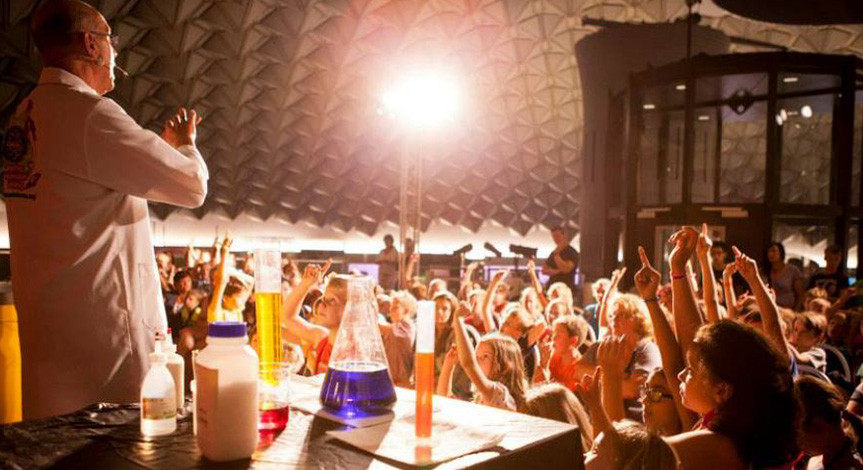 Mad scientist on stage with kids sitting on the floor